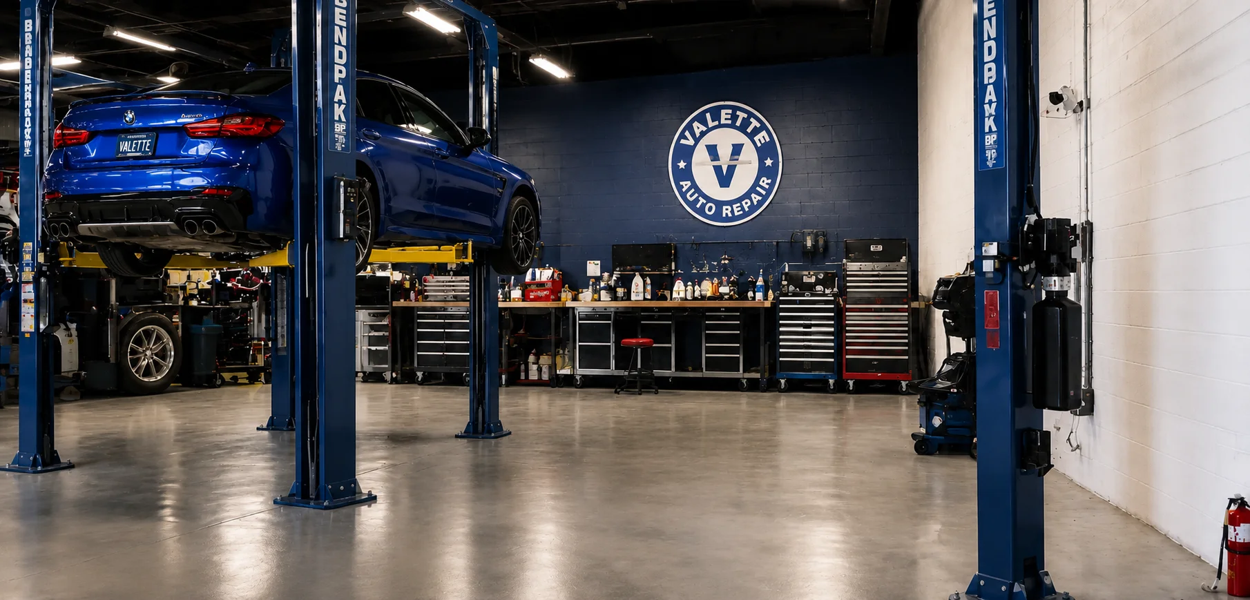 Valette Auto Repair service bay with a BMW on a lift and the shop logo on the wall