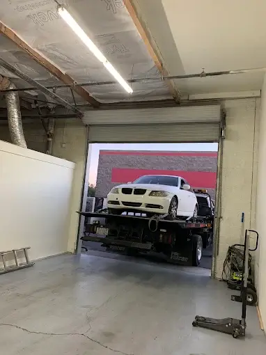BMW being delivered by flatbed tow truck to Valette Auto Repair in Chandler