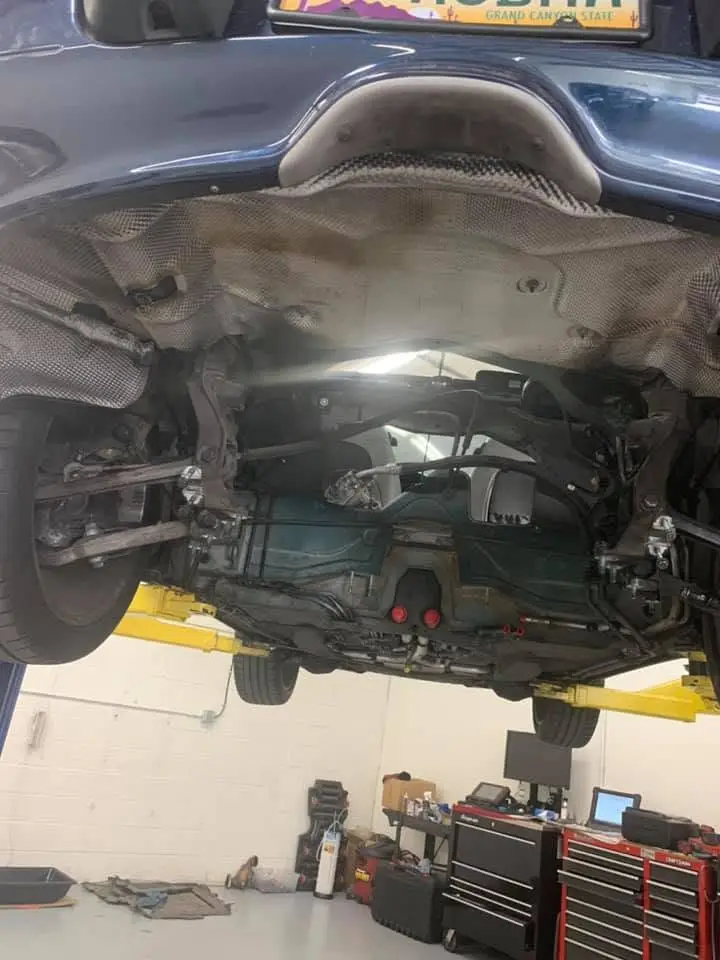 Porsche undercarriage inspection and repair on a lift at the Chandler shop